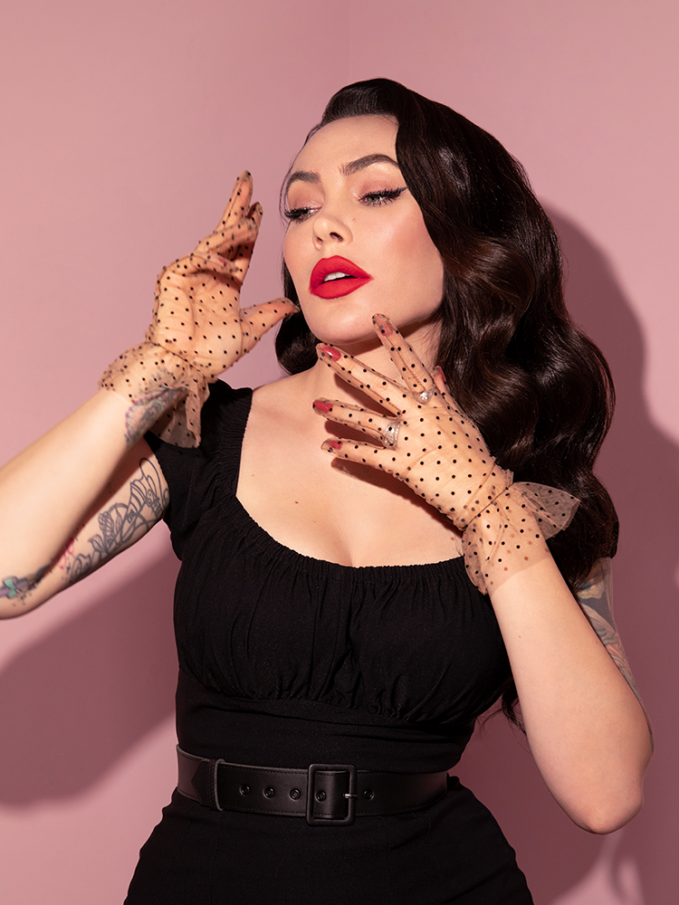 Micheline slightly turns her head to the left while modeling the Mesh Polka Dot Gloves in Tan.