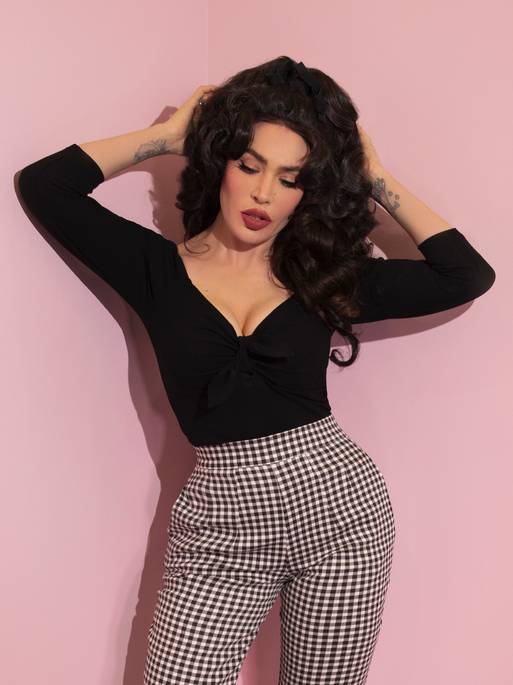 A closeup of Micheline Pitt modeling the tie me up top in black from Vixen Clothing paired with gingham pants.