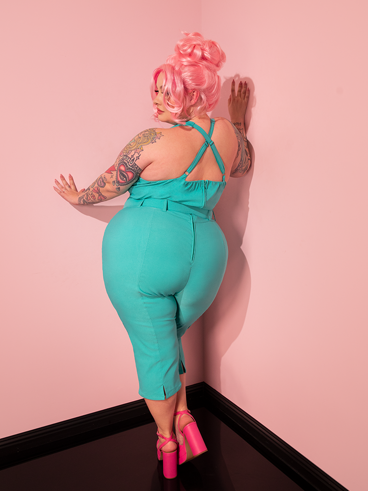 In the spotlight, a captivating vintage-style model showcases Vixen Clothing's Turquoise Capri Pants with timeless allure.