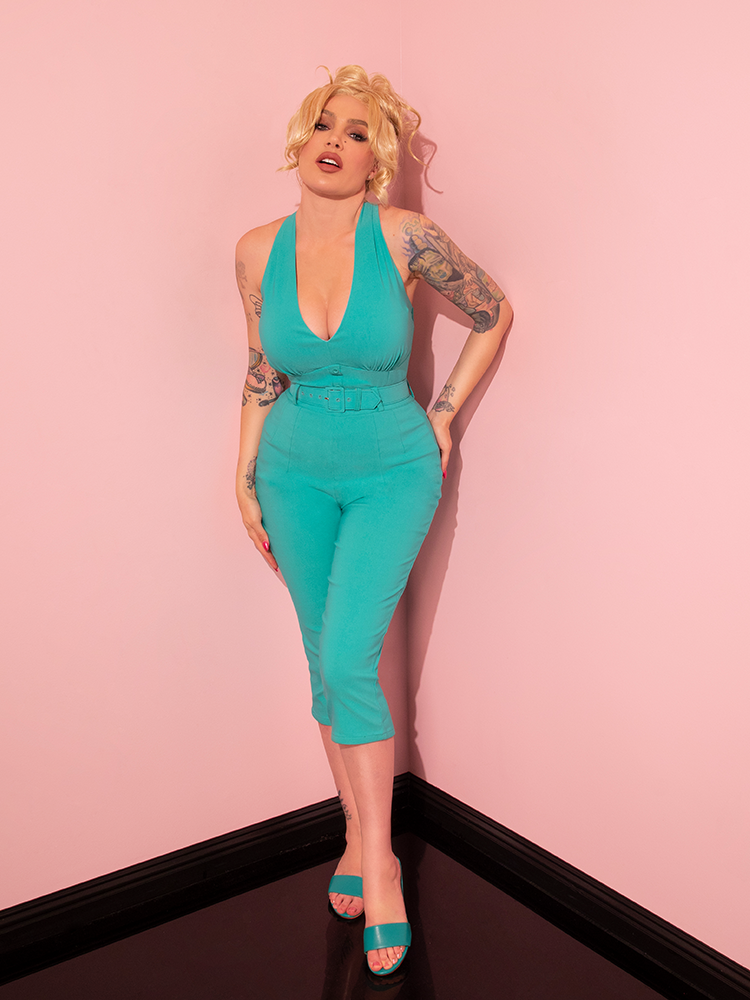 Mesmerizing the audience, a vintage-style model dons the Turquoise Capri Pants from Vixen Clothing's retro and dress collection.