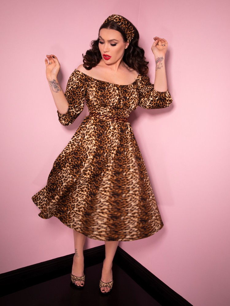 Micheline Pitt caught mid-spin in her Leopard Print Vacation Dress from Vixen Clothing.