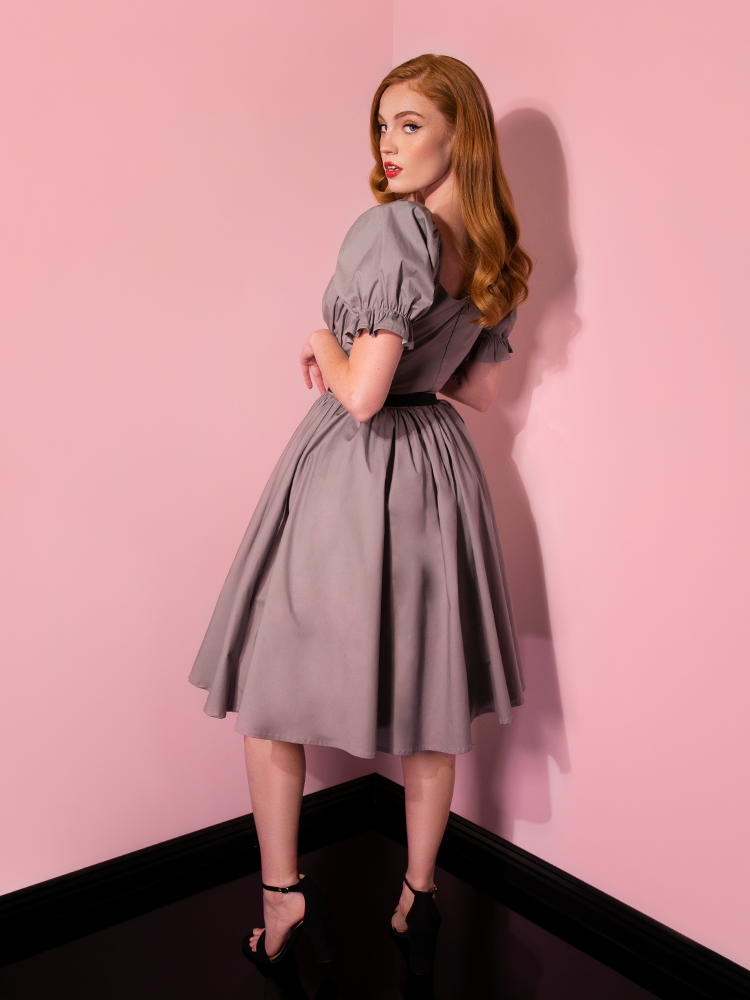 Looking over her shoulder, Emily models the Pennywise babydoll dress from Vixen Clothing.