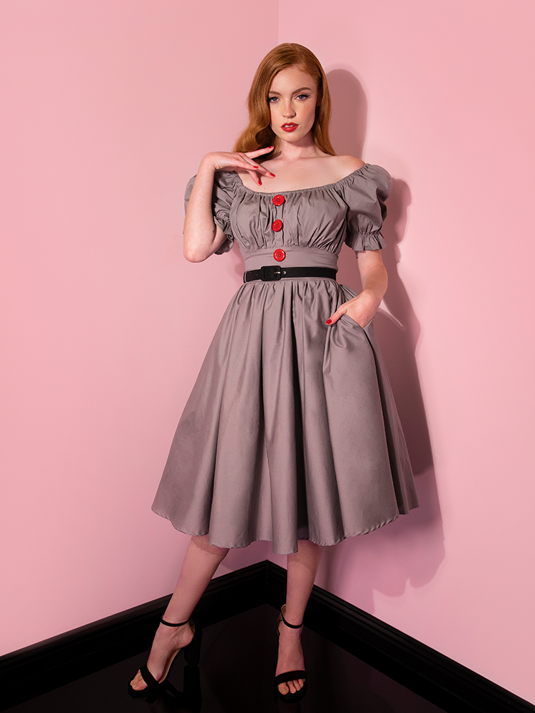 Looking into the camera, Emily models the Pennywise babydoll dress from Vixen Clothing with the sleeves off the shoulder.