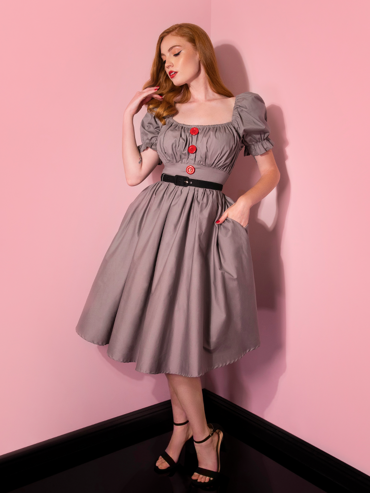 Looking down from the camera with her hand in her pocket, Emily models the Pennywise babydoll dress from Vixen Clothing.