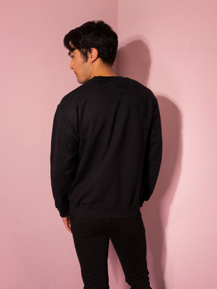Turned away from the camera and looking to the side, Ethan models the Time to Float sweatshirt by Vixen Clothing.