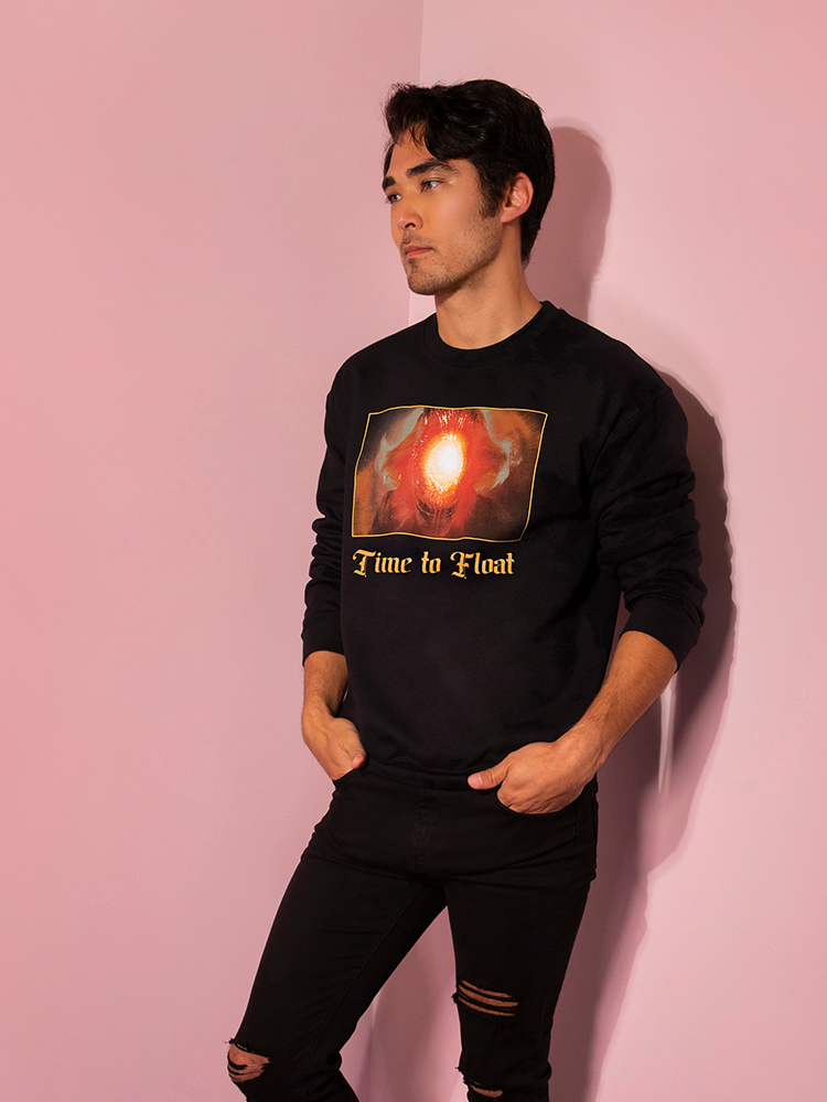 Looking to the side with his hands in his pockets, Ethan models the Time to Float sweatshirt by Vixen Clothing.