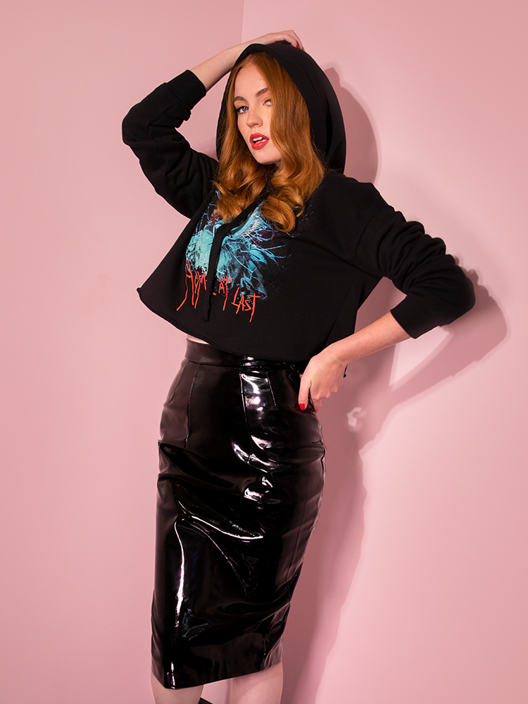 With one hand on her head and the other on her hip, Emily models the Home At Last cropped hoodie by Vixen Clothing.