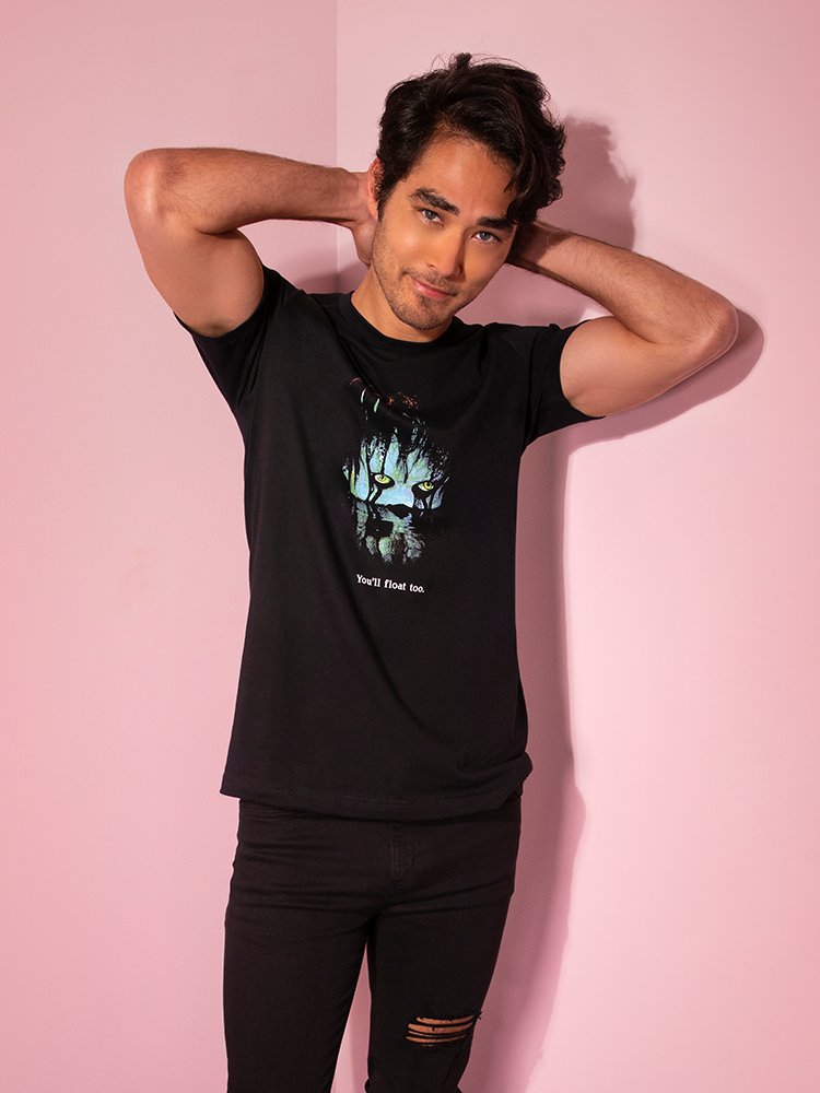 Looking at the camera with his hands behind his head, Ethan models the Pennywise float tee by Vixen Clothing.