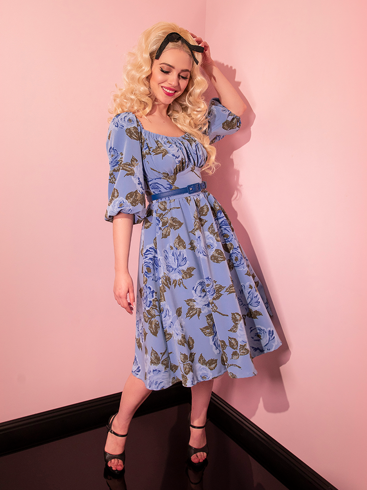 Sofia smiles and sways while wearing the Vacation Dress in Sunset Blue Roses. 