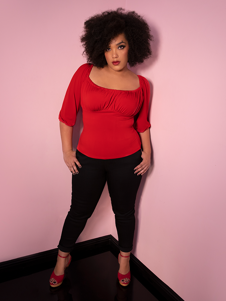 Full body shot of Ashleeta wearing a vintage inspired red top and black fitted pants