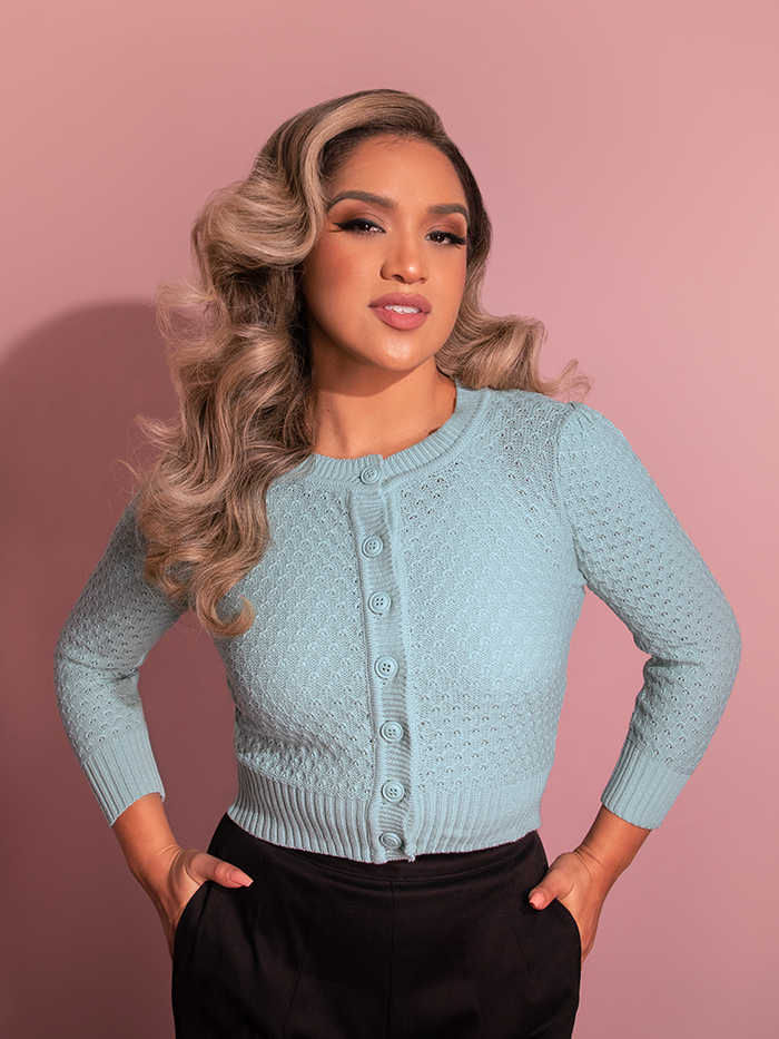 With a cute pose, Gaby models the all-new Vintage-Style Cropped Crew Neck Knit Cardigan in Light Blue from Vixen Clothing.