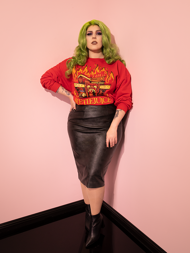 Full length shot of female model with green hair wearing a Dante's Inferno Sweatshirt with a vegan leather skirt and black ankle boots.