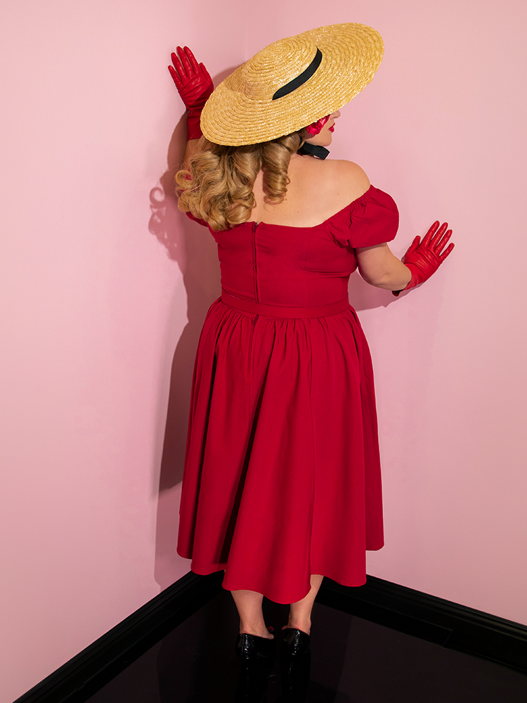 Blondie turned away from the camera to show off the back of her red retro dress.