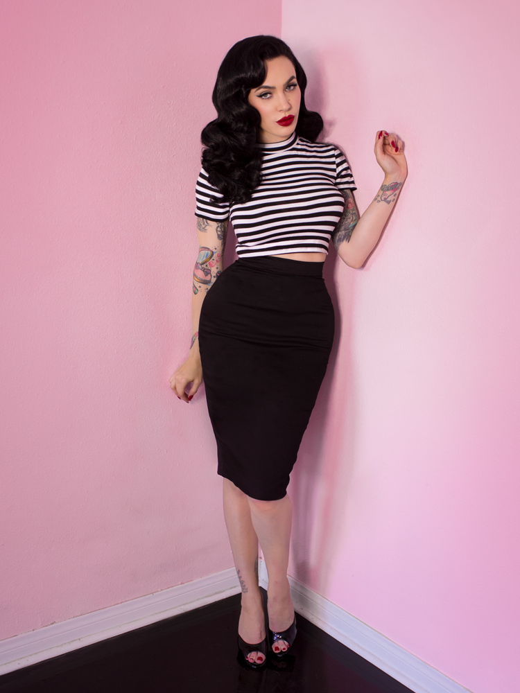 Full length shot of Micheline Pitt standing in the Bad Girl Crop Top in Black and White Stripes.