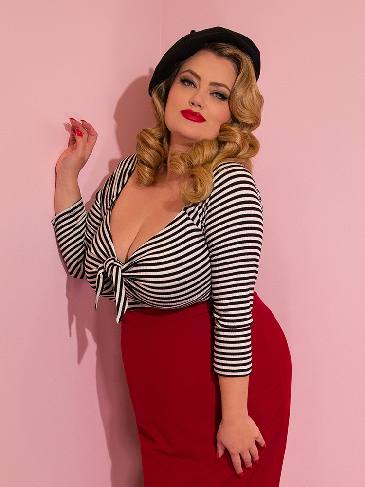 Blondie wearing the Tie Me Up Top in Black and White Stripes from Vixen Clothing paired with a red skirt and black beret.