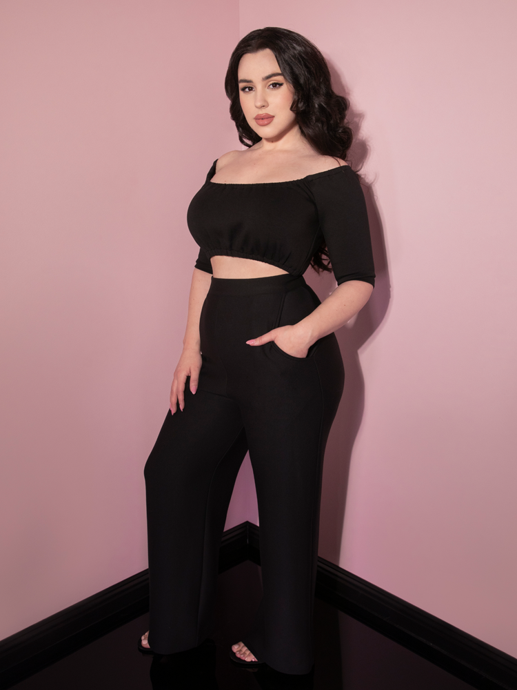 Rachel Sedory, turned to the side, shows off a profile shot of the Cozy Lounge Pants in Black from Vixen Clothing.