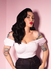 A closeup of Micheline Pitt modeling the Powder Puff top in white paired with retro jeans.