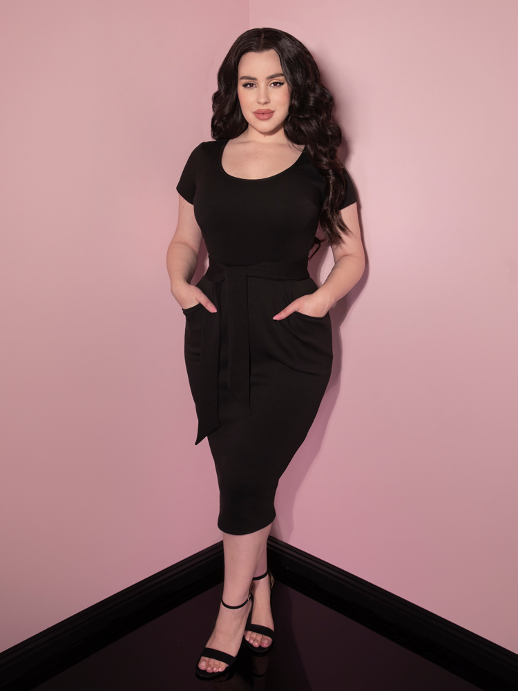 Rachel Sedory shows off the pockets of the Cozy Wiggle Dress in Black from Vixen Clothing.